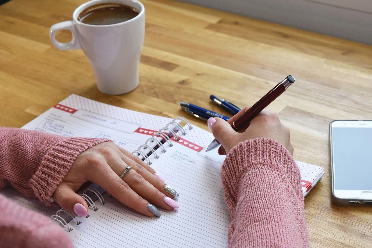 Notes z długopisem na biurku — krótka notatka po prezentacji jako tani kurs public speaking