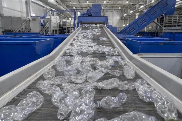 Plastikowe butelki PET na taśmie w sortowni - recykling plastiku